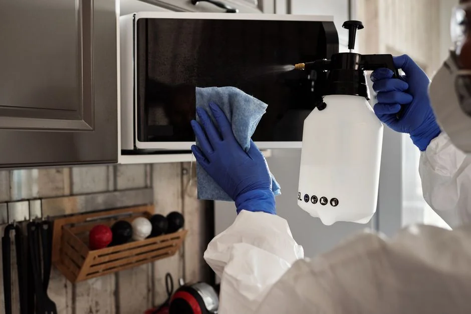 brand-01 A person in full PPE gear standing indoors, emphasizing disinfection during COVID-19.